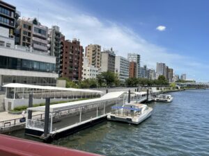 隅田川沿いの水上バス乗り場。屋根付き通路と数隻の船が整然と停泊している。
