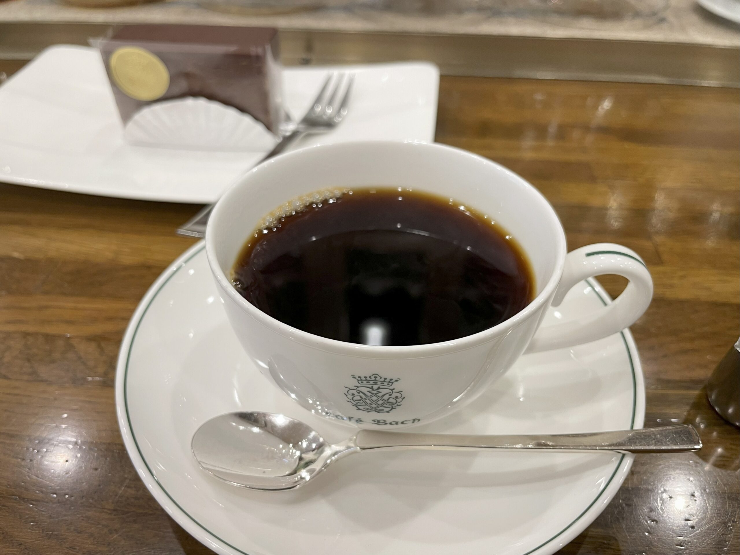 奥にチョコレートケーキ、手前にコーヒーが置かれている。