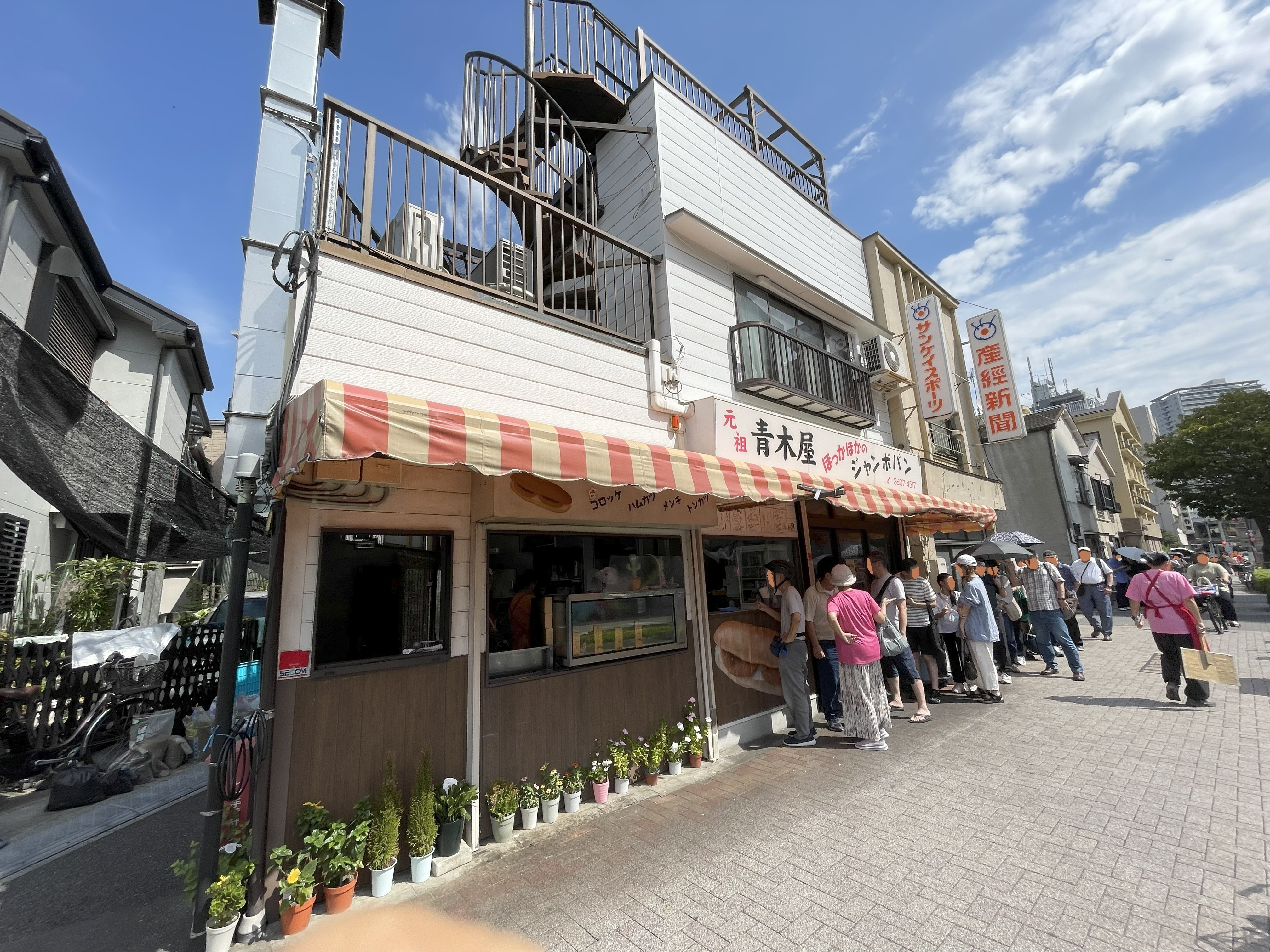 元祖・青木屋さんの店舗前にできた長い行列。赤と黄色のテントが目印の人気店。