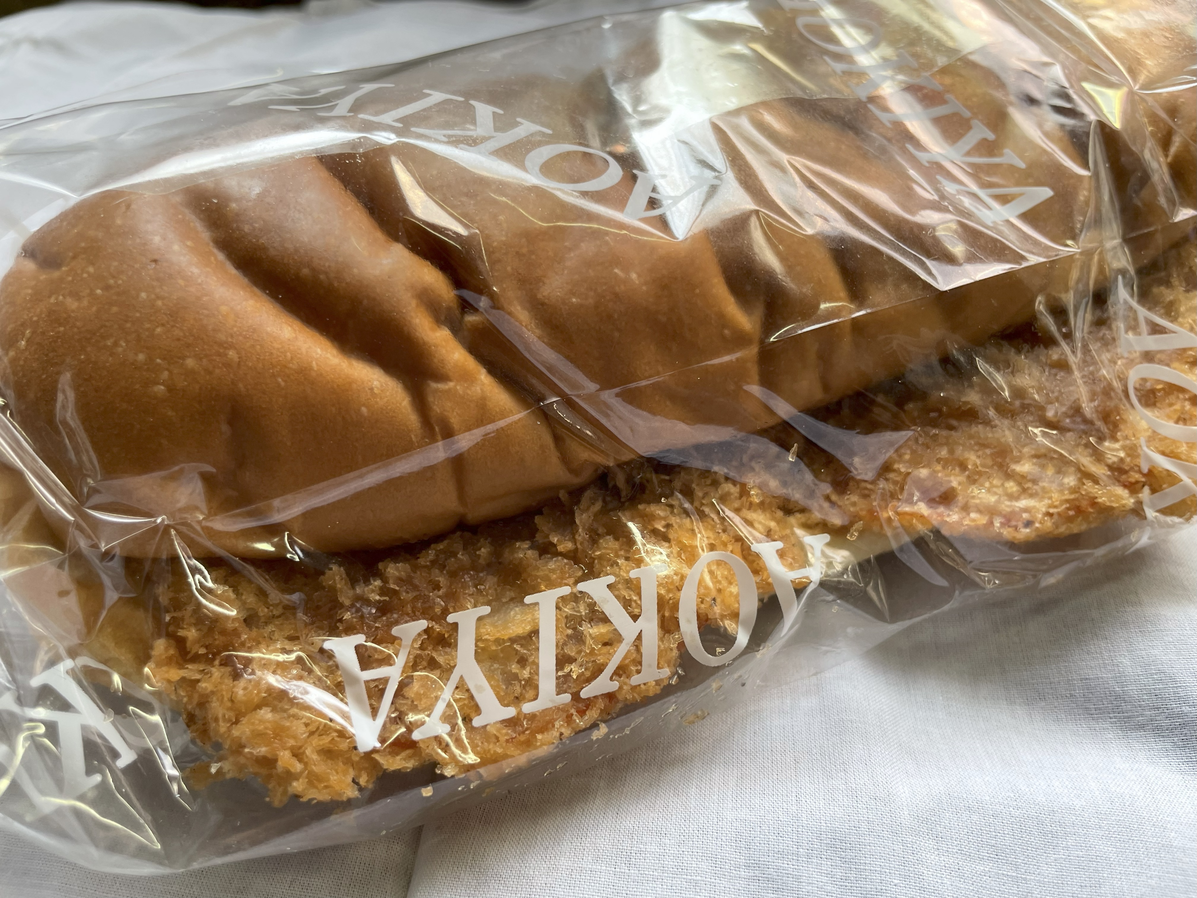 青木屋さんのハムかつパン。袋越しに見える揚げたてのハムカツと、ふっくらパン。