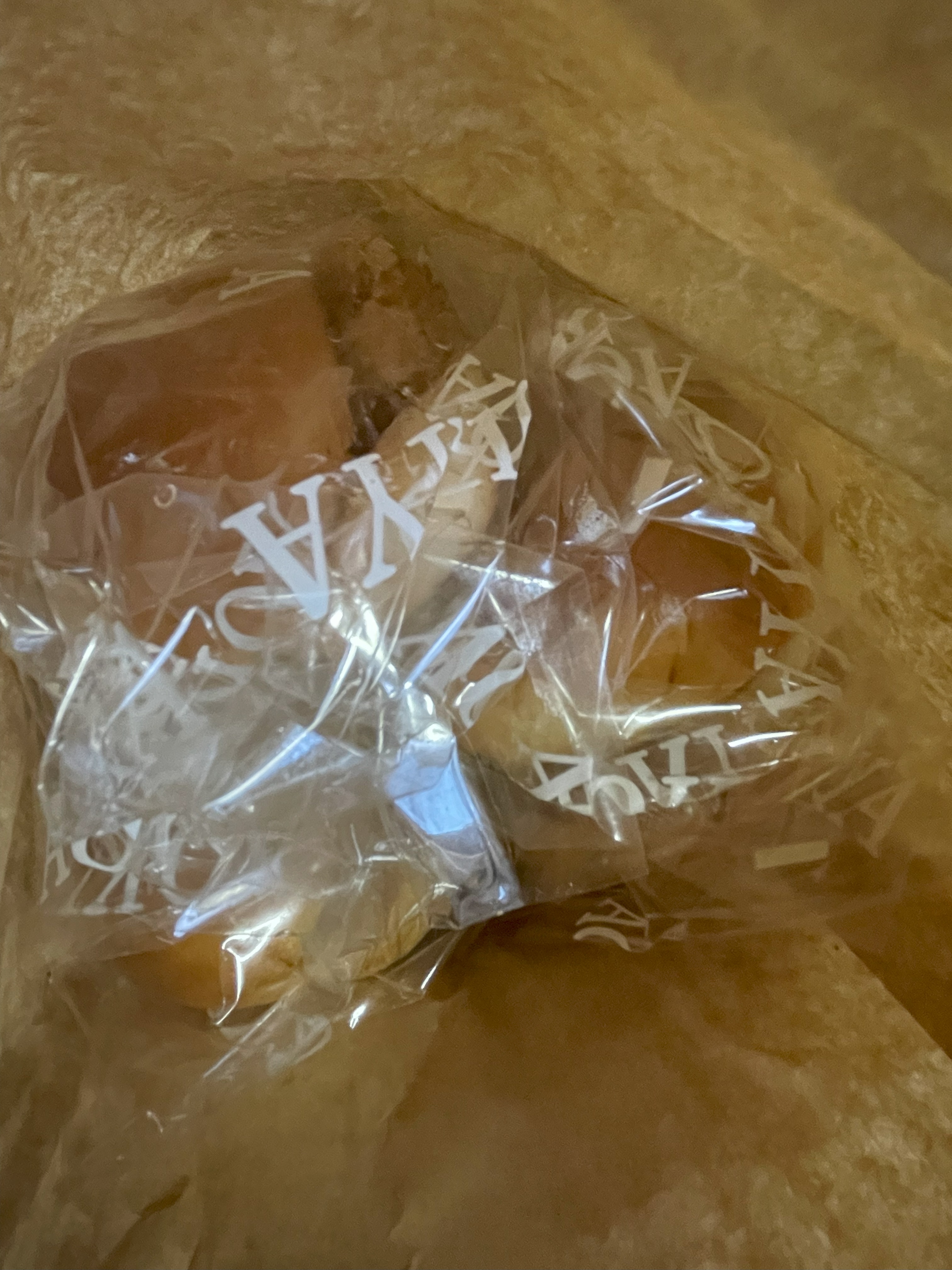 青木屋さんの紙袋の中に入ったジャンボパンが透明な袋に包まれて並んでいる様子。