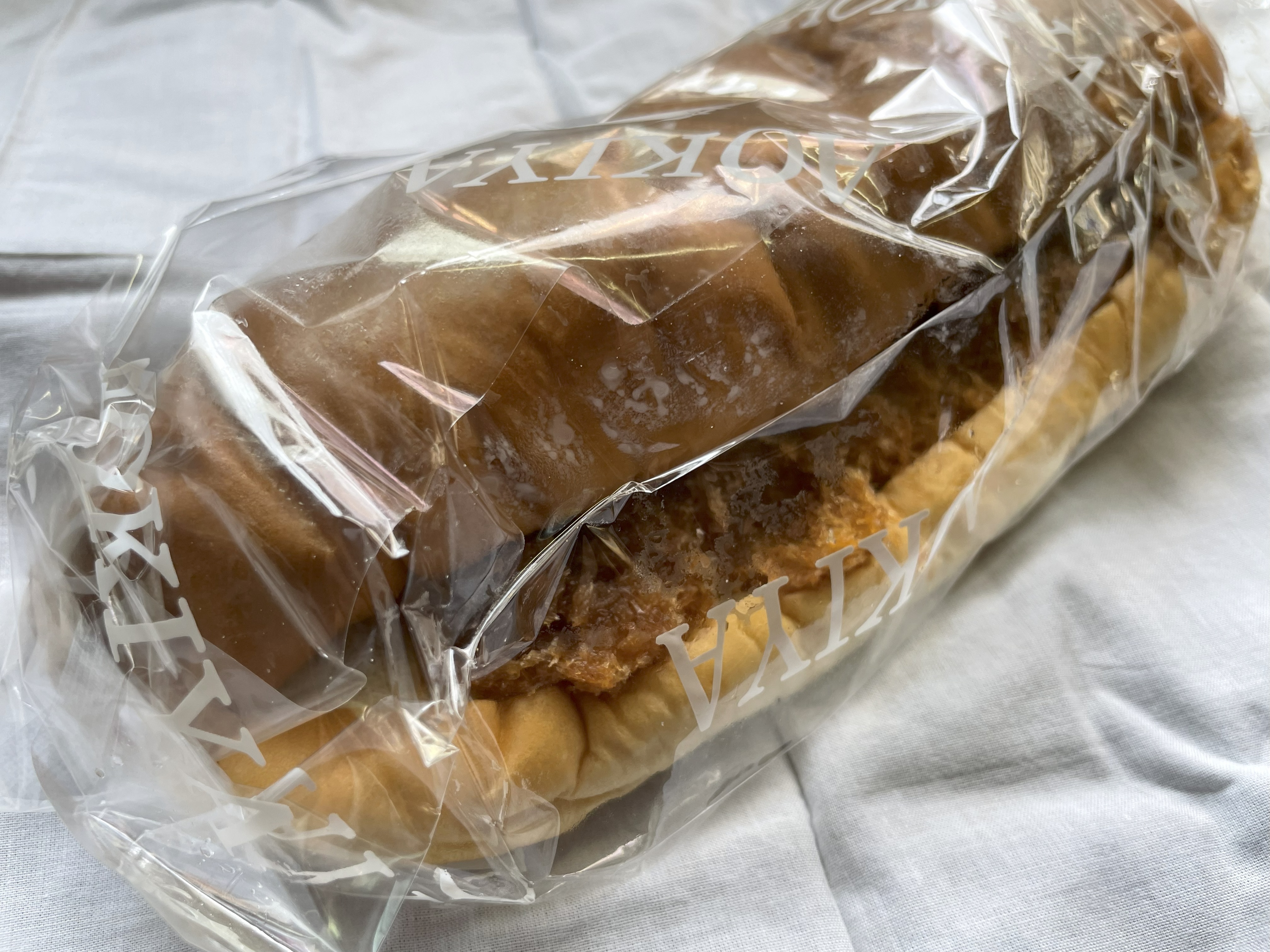 青木屋さんのとんかつパン。分厚いとんかつがコッペパンからはみ出すほどボリュームがある。