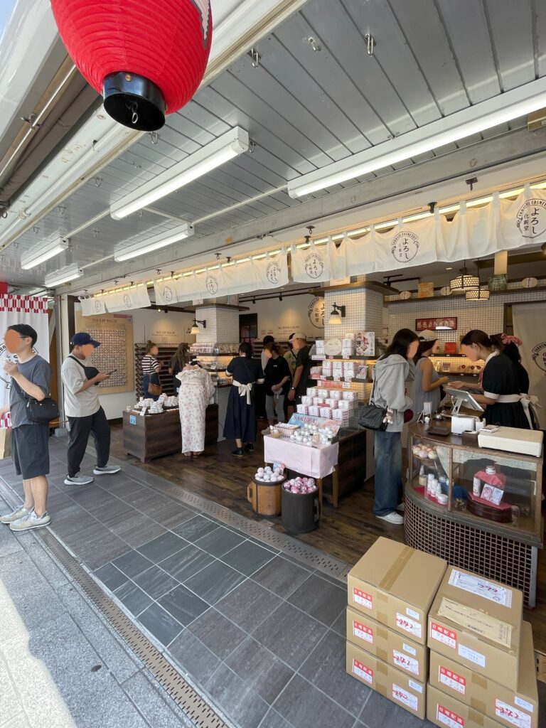 仲見世になるコスメ専門店。女性客たちが商品を見たり、スタッフの女性に商品説明を受けている。