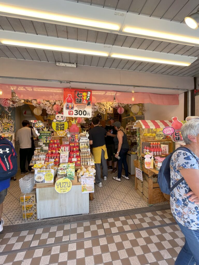 仲見世にある七味の専門店。可愛いポップもあり、明るい店内で買い物をする観光客。
