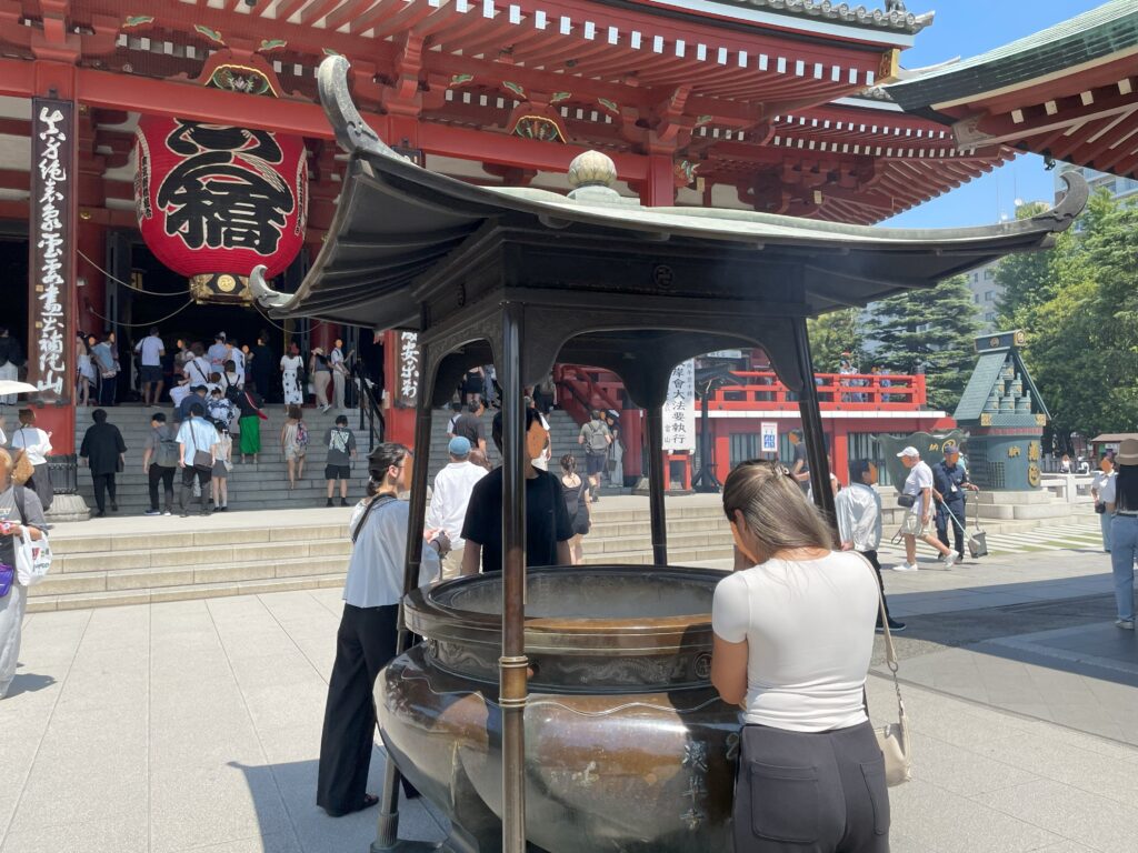 ご本堂の前に置かれたお線香の煙を浴びる常香炉（じょうこうろ）。