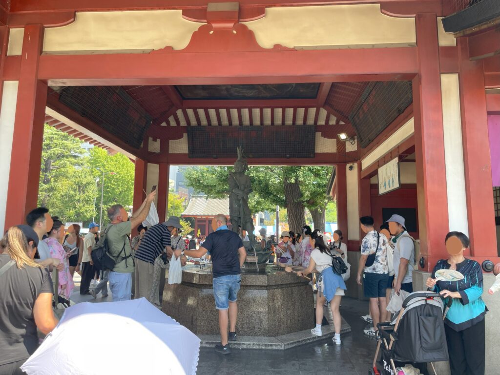 ご本堂の前にあるお水舎（おみずや）に、多くの参拝者が集まっている。