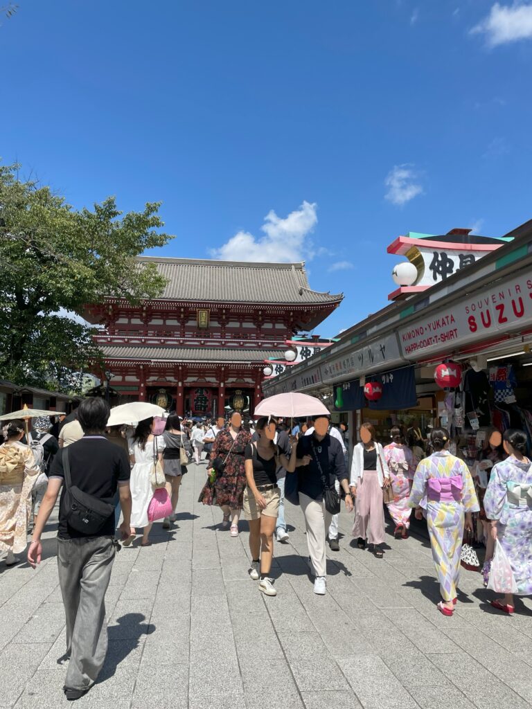 美しい青空。浅草寺へと続く仲見世。多くの観光客が歩いている。