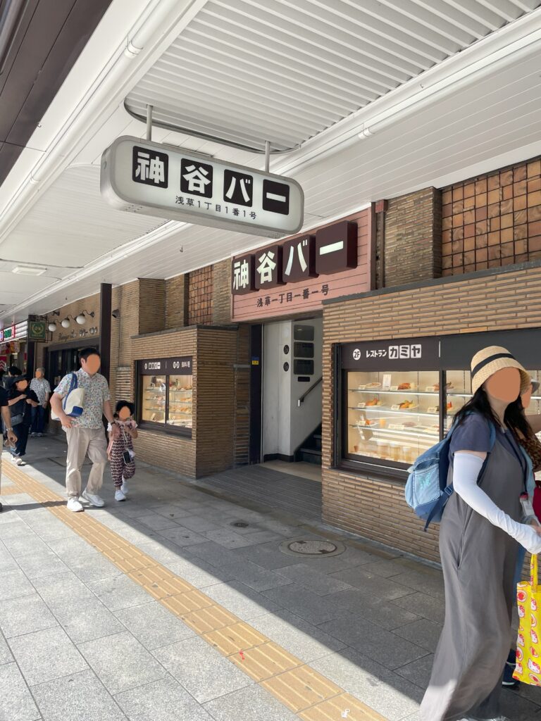 「神谷バー」の入口。雷門通りに面しており、人々が歩いている。