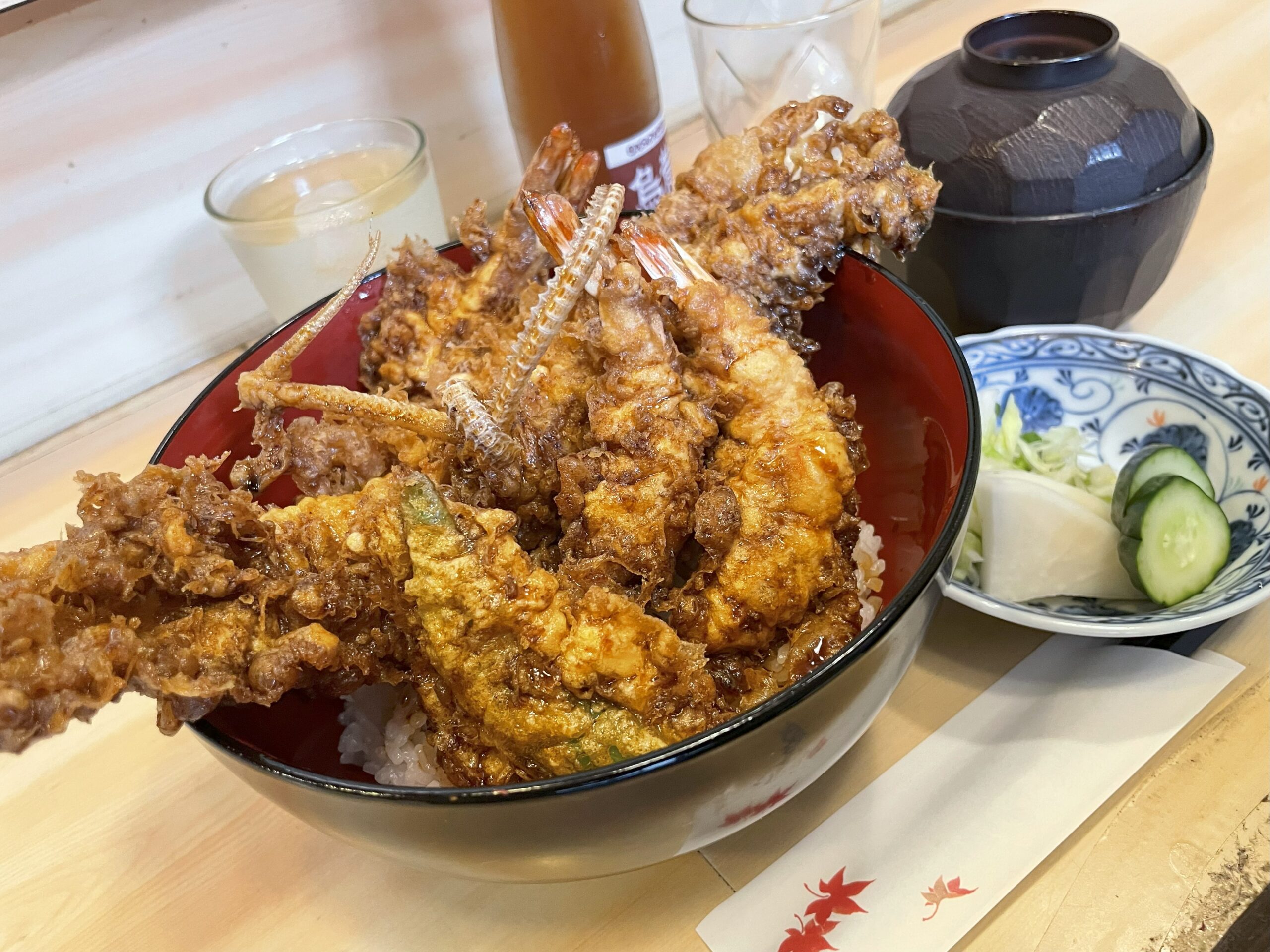 揚げたての天ぷら定食。衣はサクサク、えびはぷりっとした食感。穴子の骨せんべいが添えられ、香ばしさが伝わる。