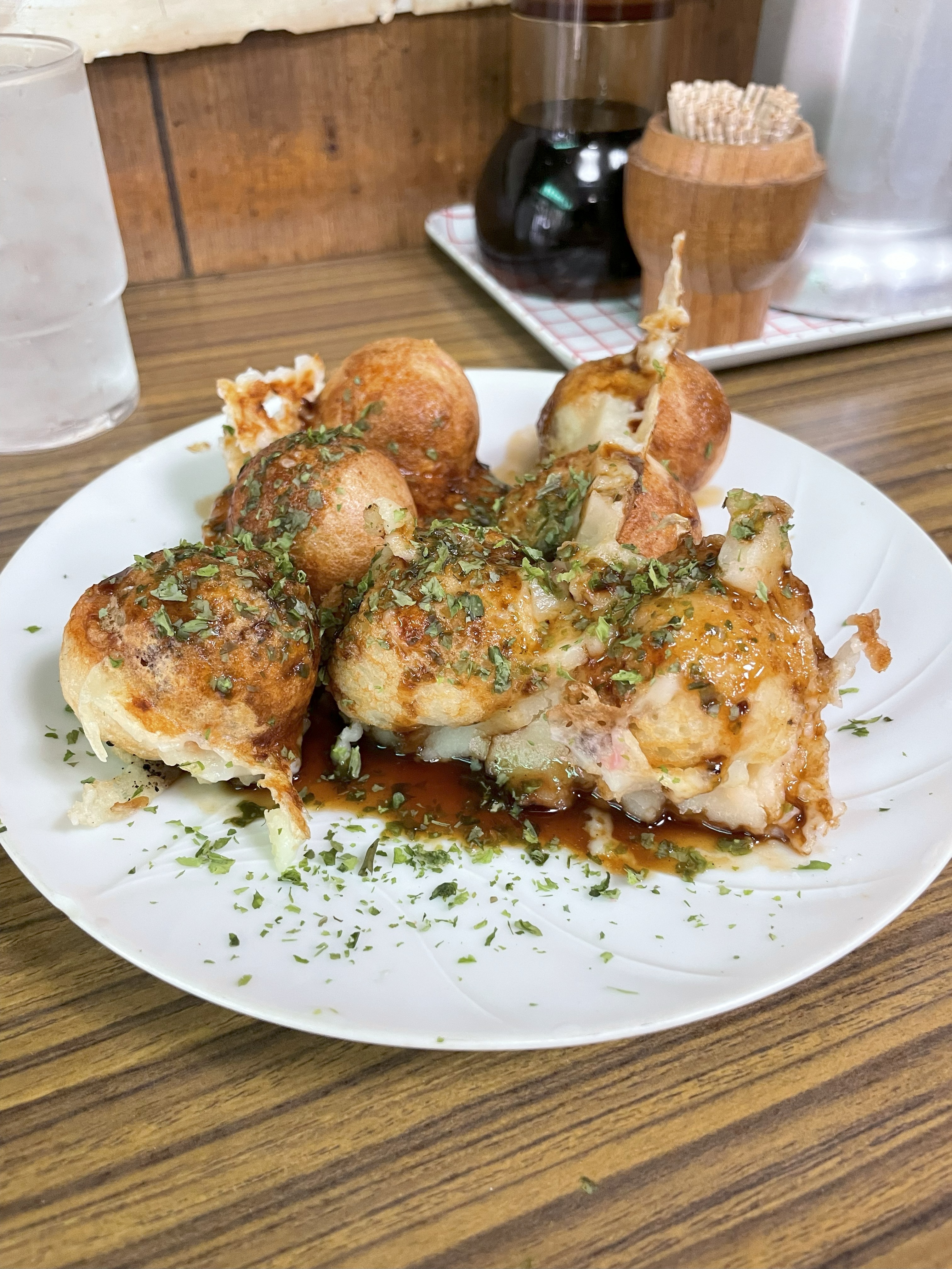 カウンターテーブルに、白い皿にのった、たこ焼きが置いてある。