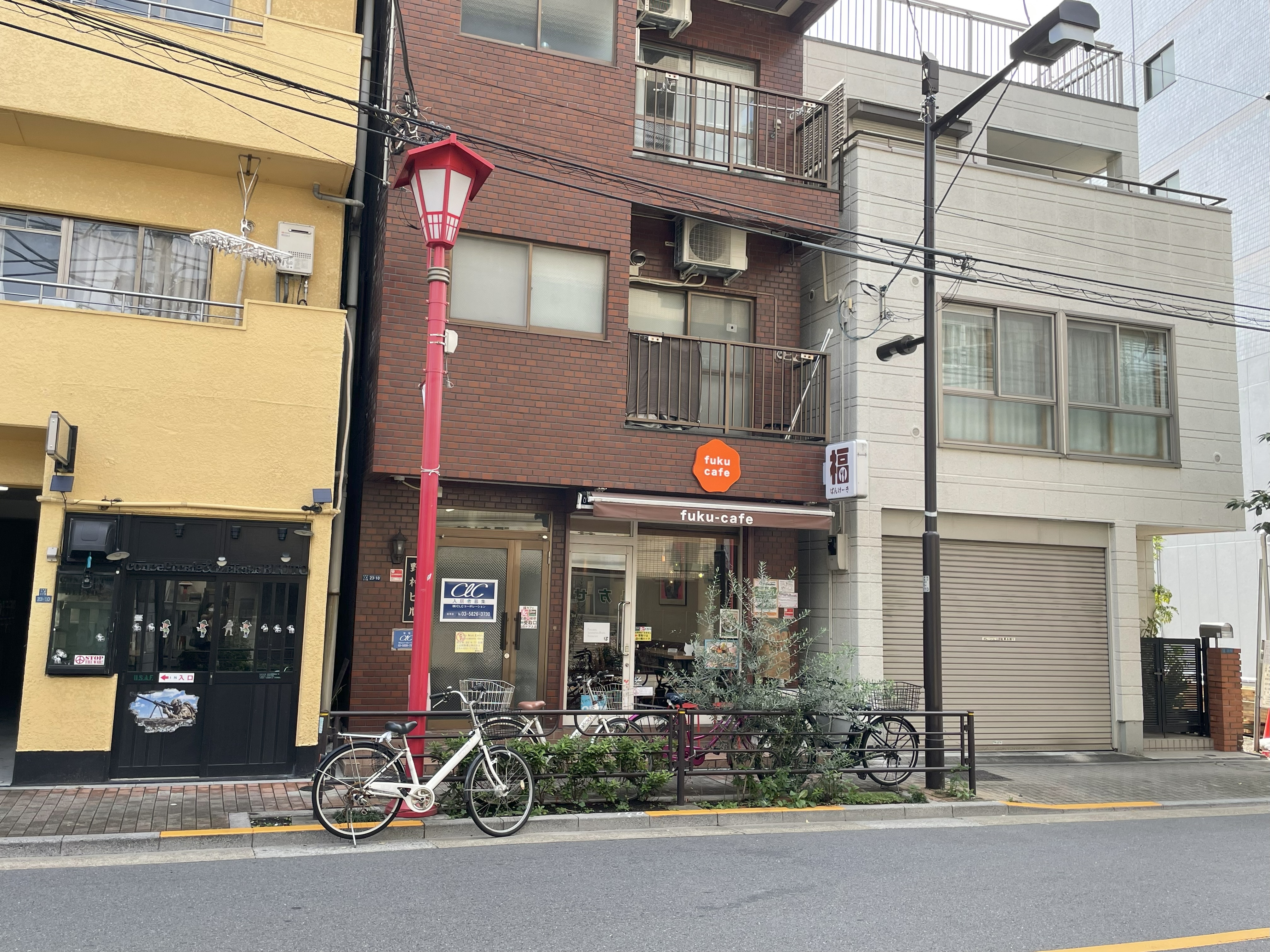 福カフェさんの店舗外観。赤い街灯と自転車が並ぶ仲之町通り沿い。