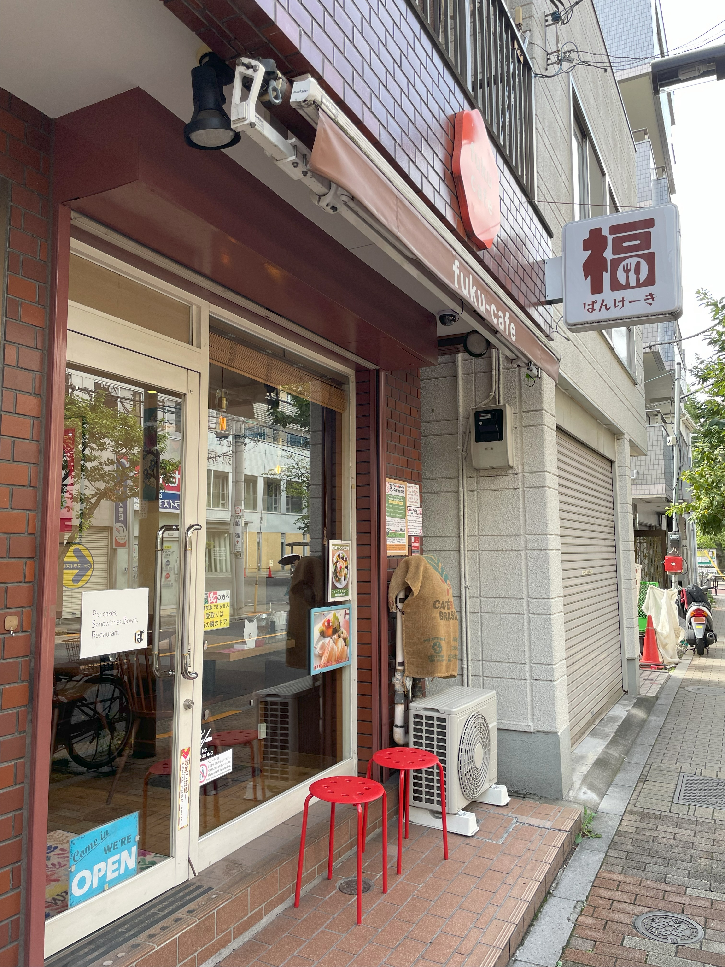 福カフェさんの店舗入口と外に置かれた赤いスツール。