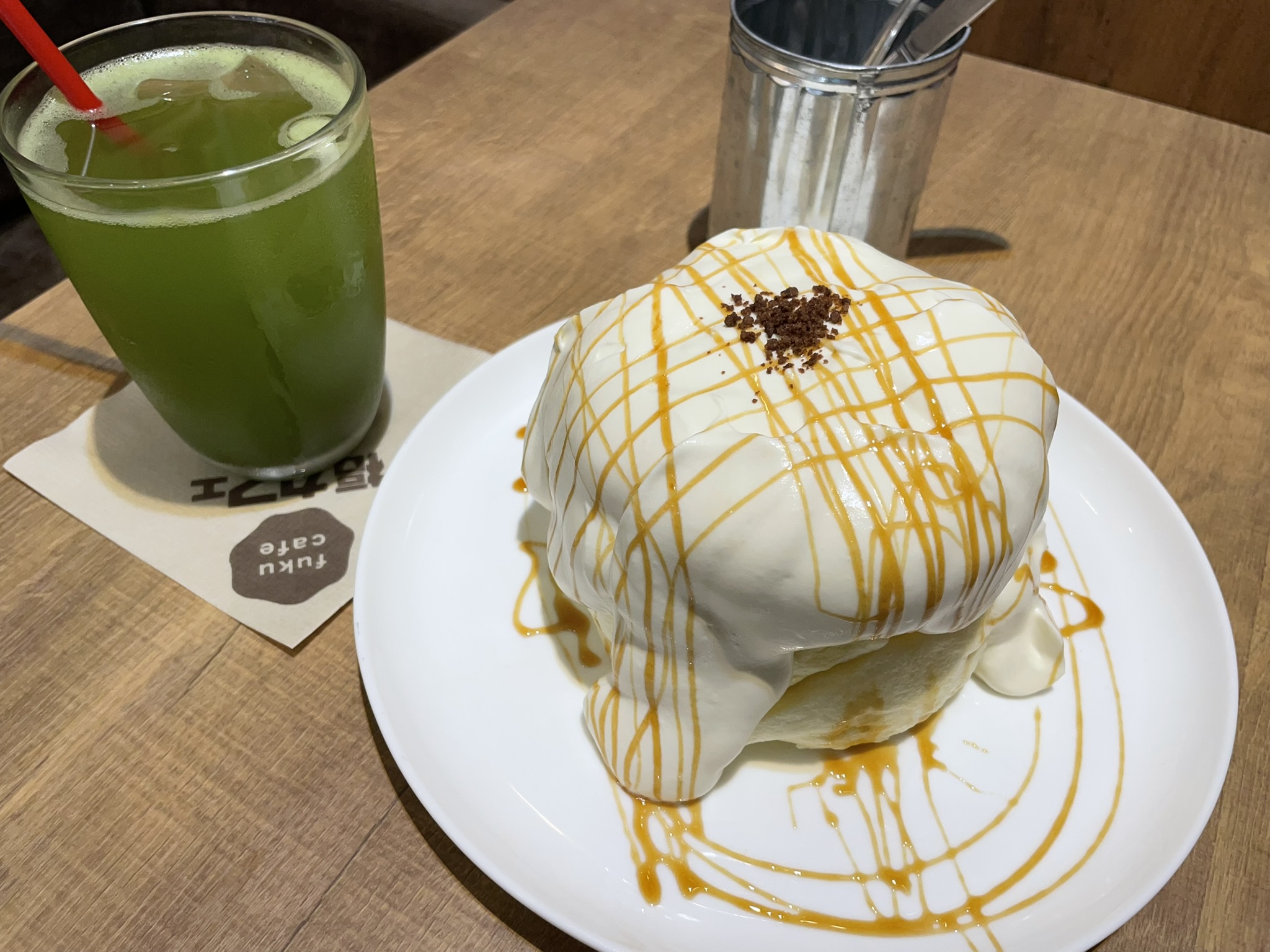 ふわふわキャラメルクリームのパンケーキと緑茶。たっぷりのホイップクリームにキャラメルソースがかかっている。
