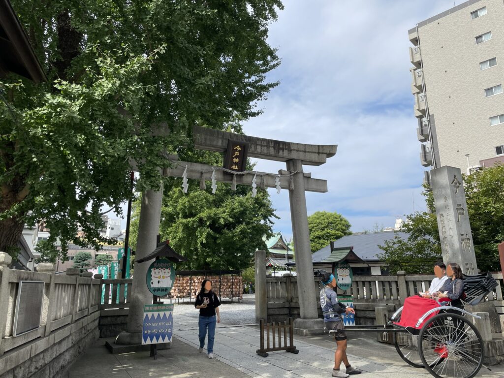 今戸神社の鳥居と人力車で訪れる参拝客の様子。