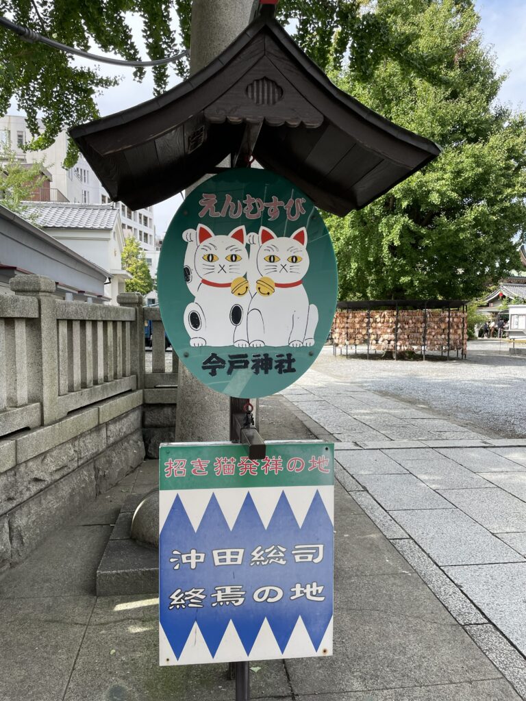 招き猫と「沖田総司終焉の地」と書かれた今戸神社の看板。