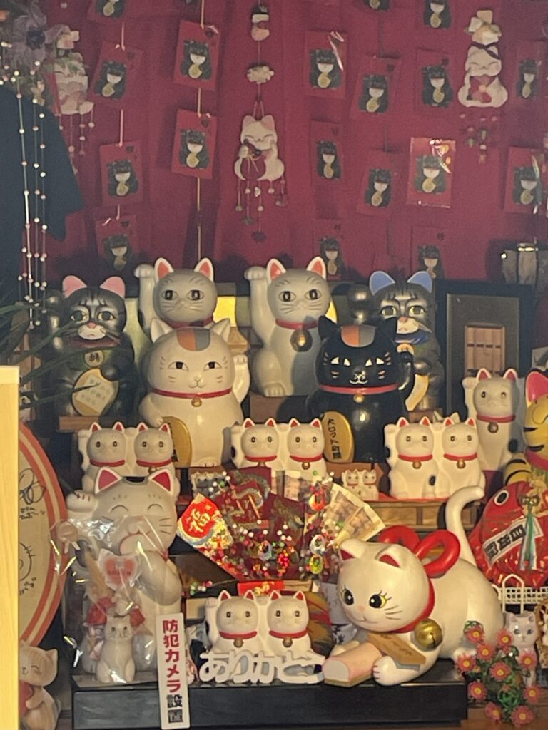 今戸神社の社務所内に並ぶ色とりどりの招き猫。「夏目友人帳」のニャンコ先生と黒ニャンコの招き猫もある。