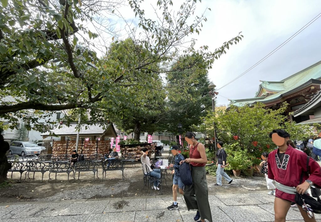 今戸神社の社殿と木陰で過ごす参拝客の風景。