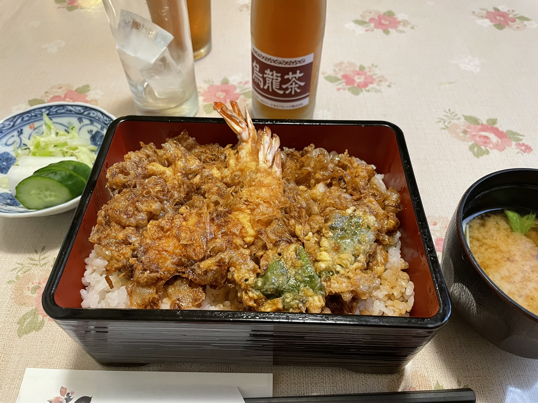 香ばしい衣の天ぷらがのった天重。味噌汁と小鉢もついている。