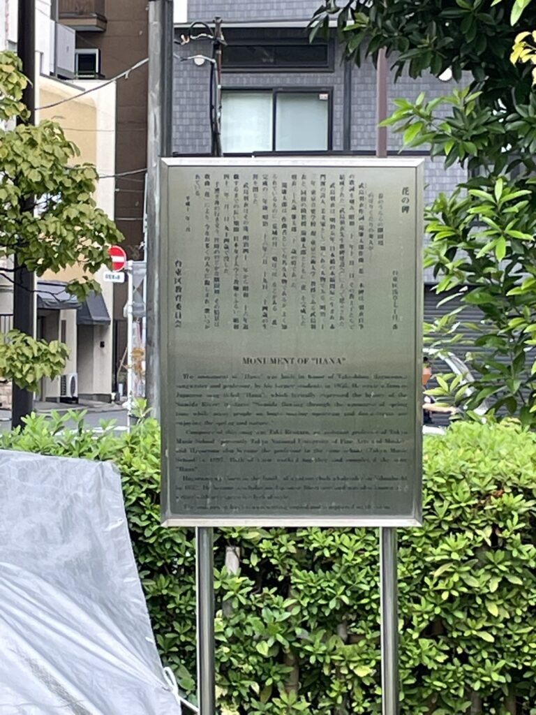 「花の碑」の説明板(日本語と英語併記)。