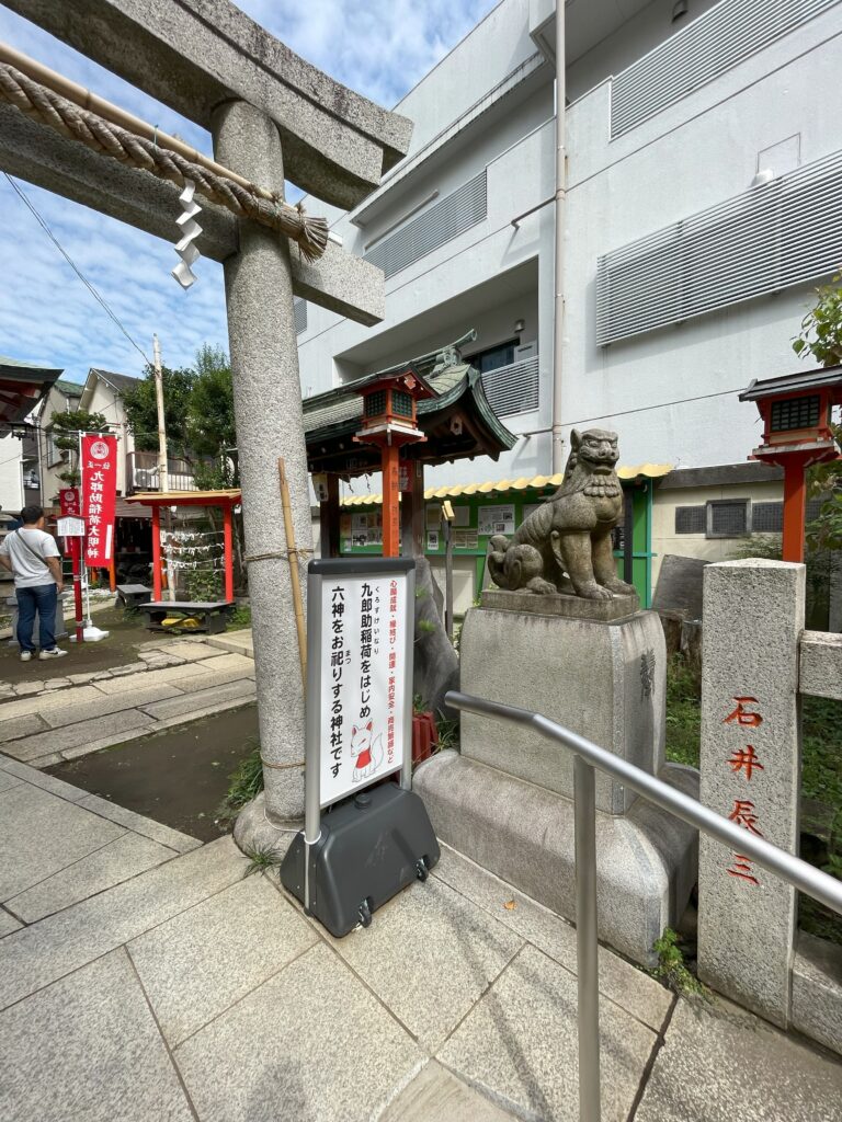 吉原神社の鳥居脇の狛犬と案内板。