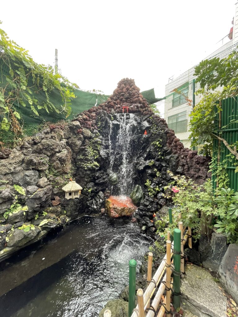 小さな鳥居のある滝と池が広がる吉原弁財天様の境内。