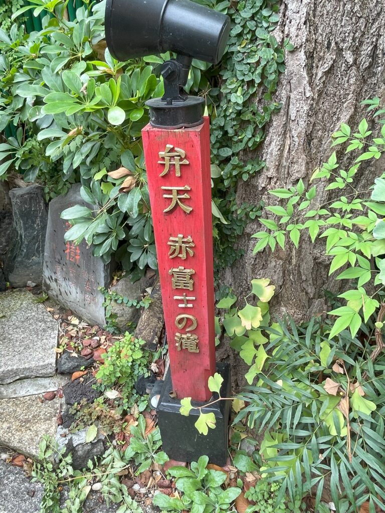 「弁天 赤富士の滝」と書かれた赤い柱の案内板。