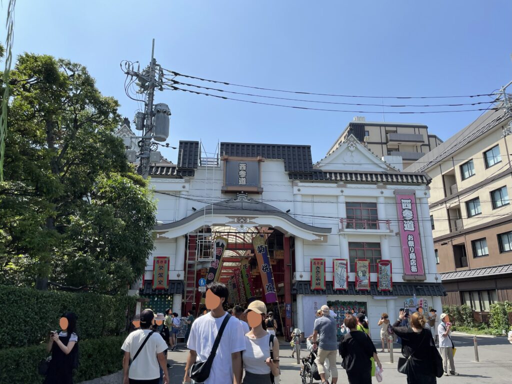 「西参道 お参り商店街」の入口。晴天の下、観光客が行き交っている。