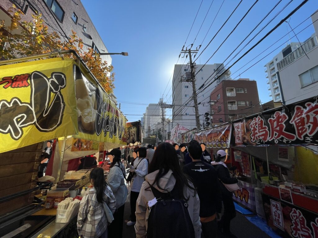 両側に屋台が立つ通りの中を、たくさんの人々が行き交っている。