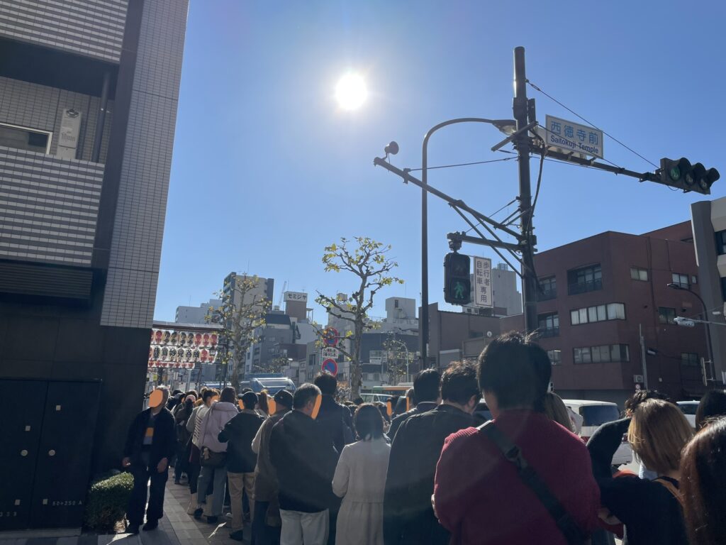 11月下旬でも、日射しが強く、暖かい。国際通りに並ぶ参拝者の列。