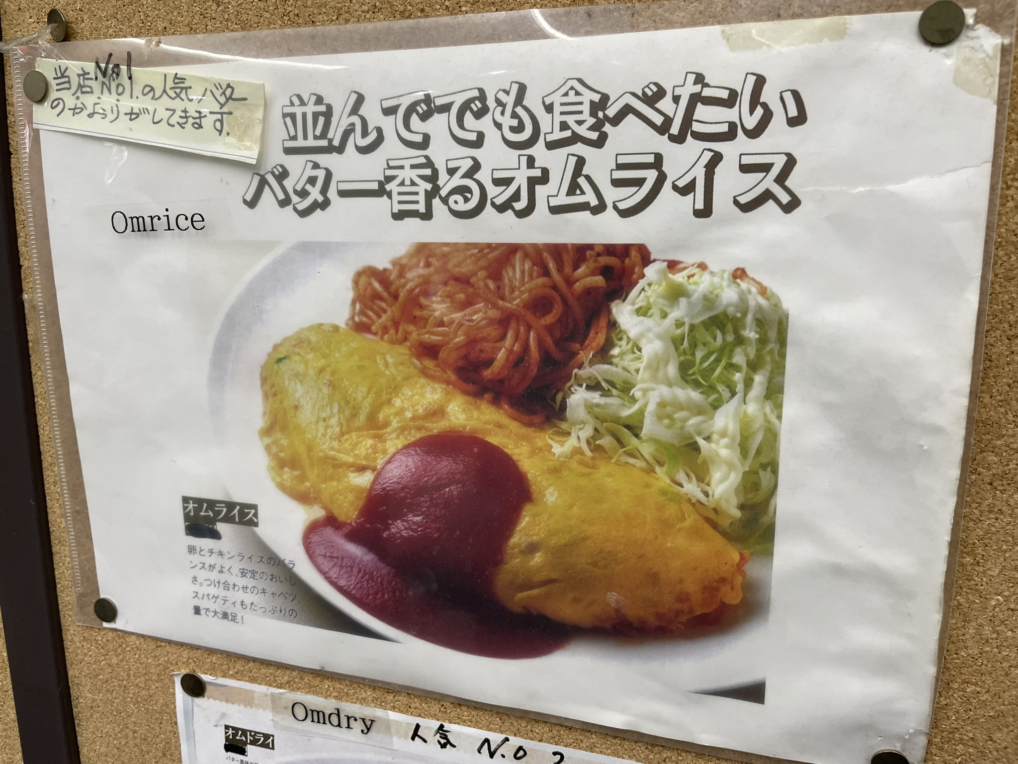 コルクボードに飾られている人気NO.1のオムライスの写真。