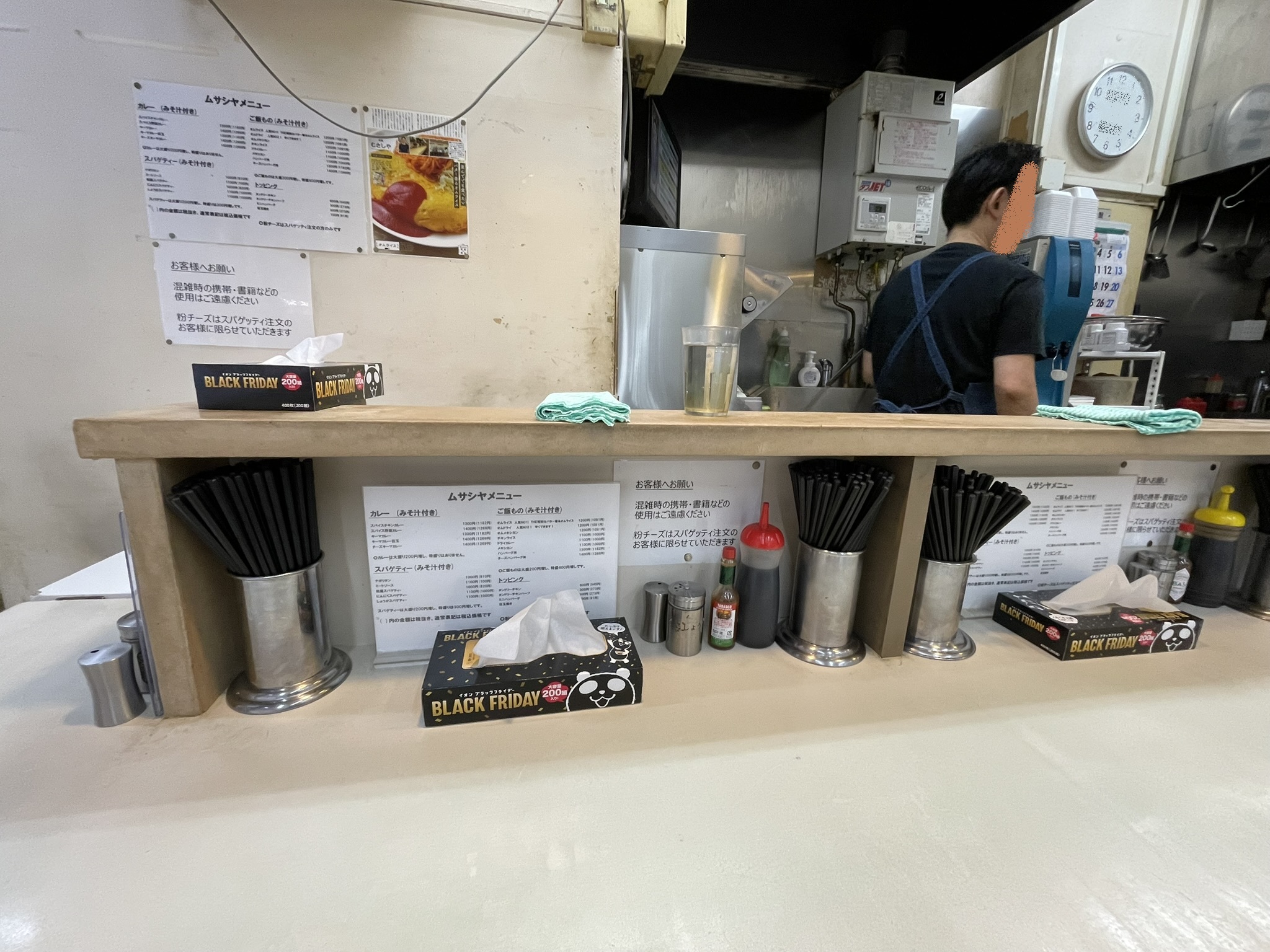 カウンター席のテーブル。メニュー表やソースなどが置かれている。