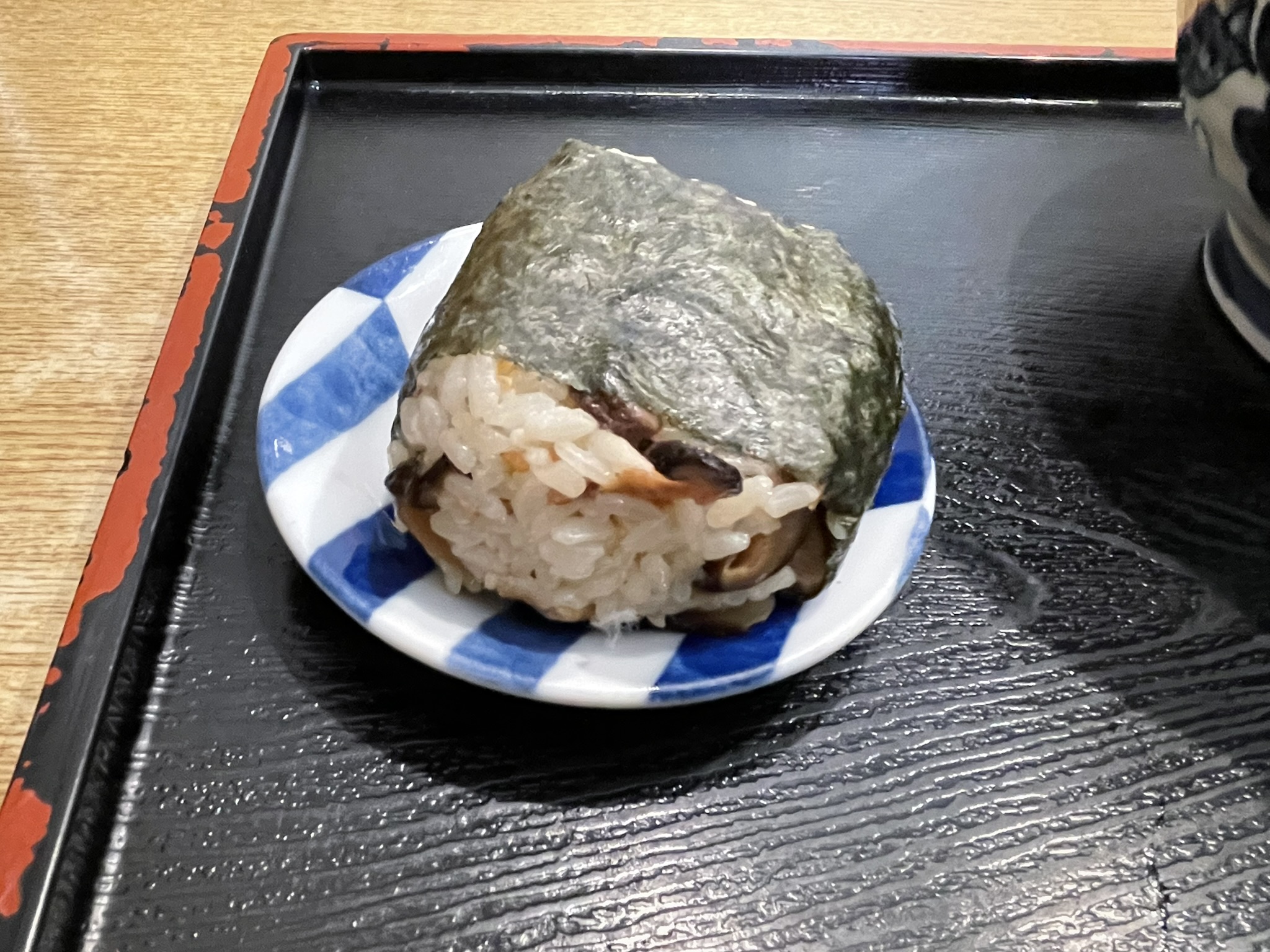 包まれたラップをはずした「おにぎりB」の写真。「稲荷風おにぎり」には、酢飯に、油あげ、しいたけ、ごまが入っている。