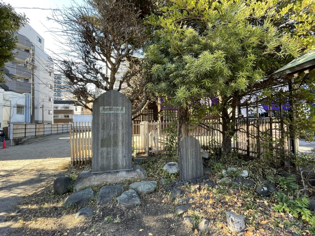 境内の樹木の側にある碑。