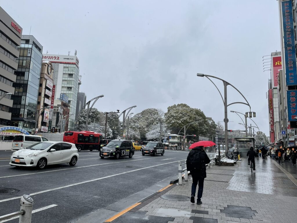 上野公園前のバス通り。多くの車と人が行き来っている。