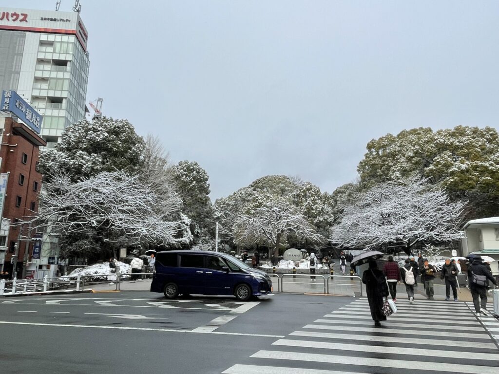 京成上野駅近くの上野公園入口。公園内の木に雪が積もっている。