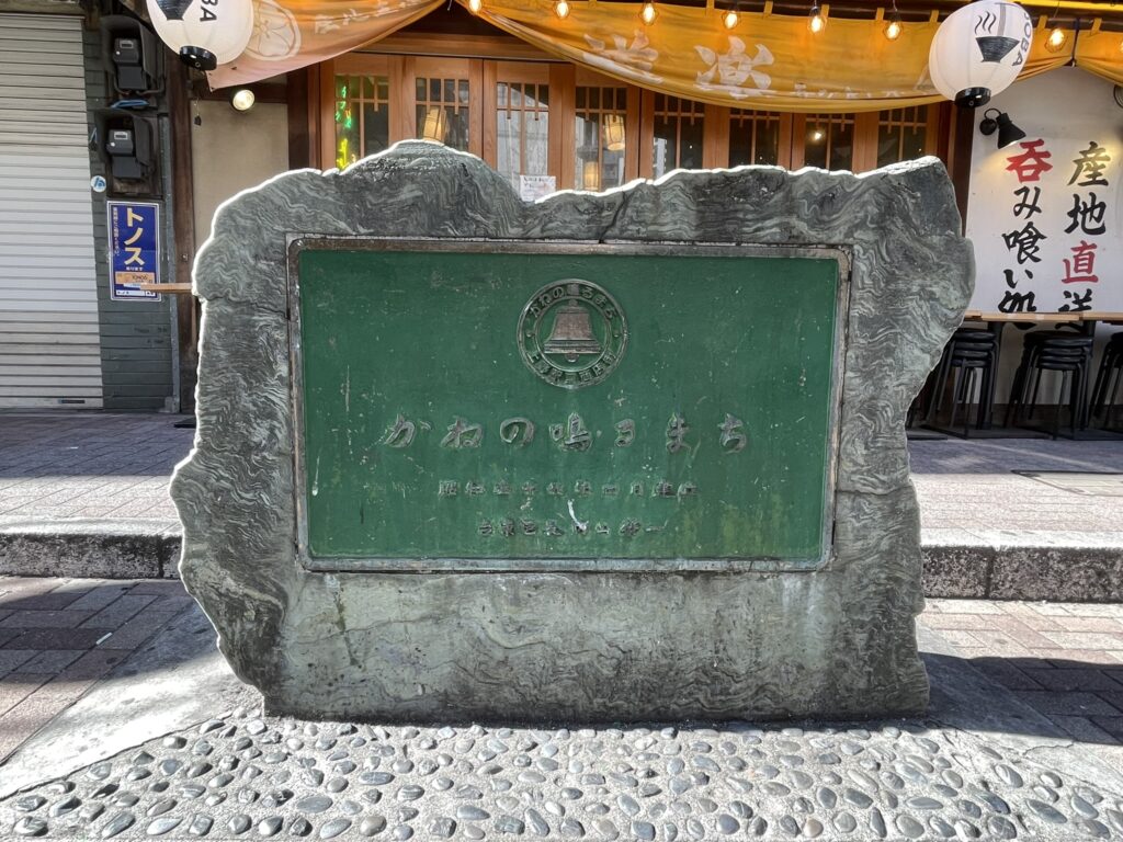 上野駅前商店街の通りにある「かねの鳴るまり」の碑の全体。