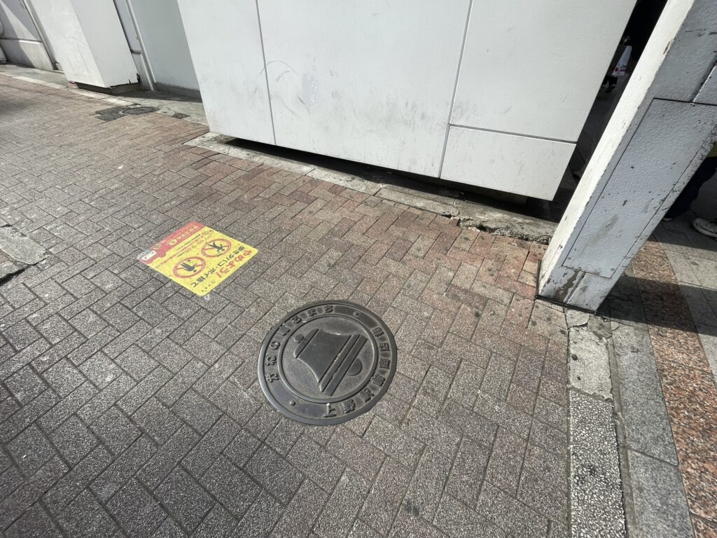 上野駅前商店街の通り。その入口近くにはレリーフが埋め込まれている。