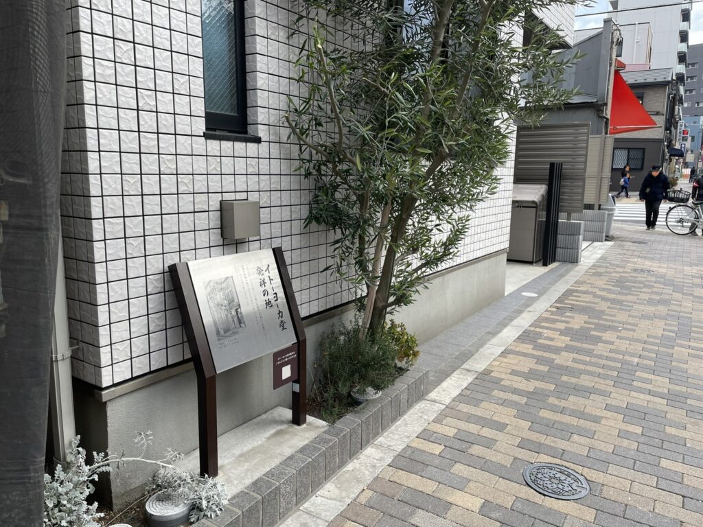 碑の近くには「アサヒ商店街（アサヒ会通り）」「日の出会商店街」がある。