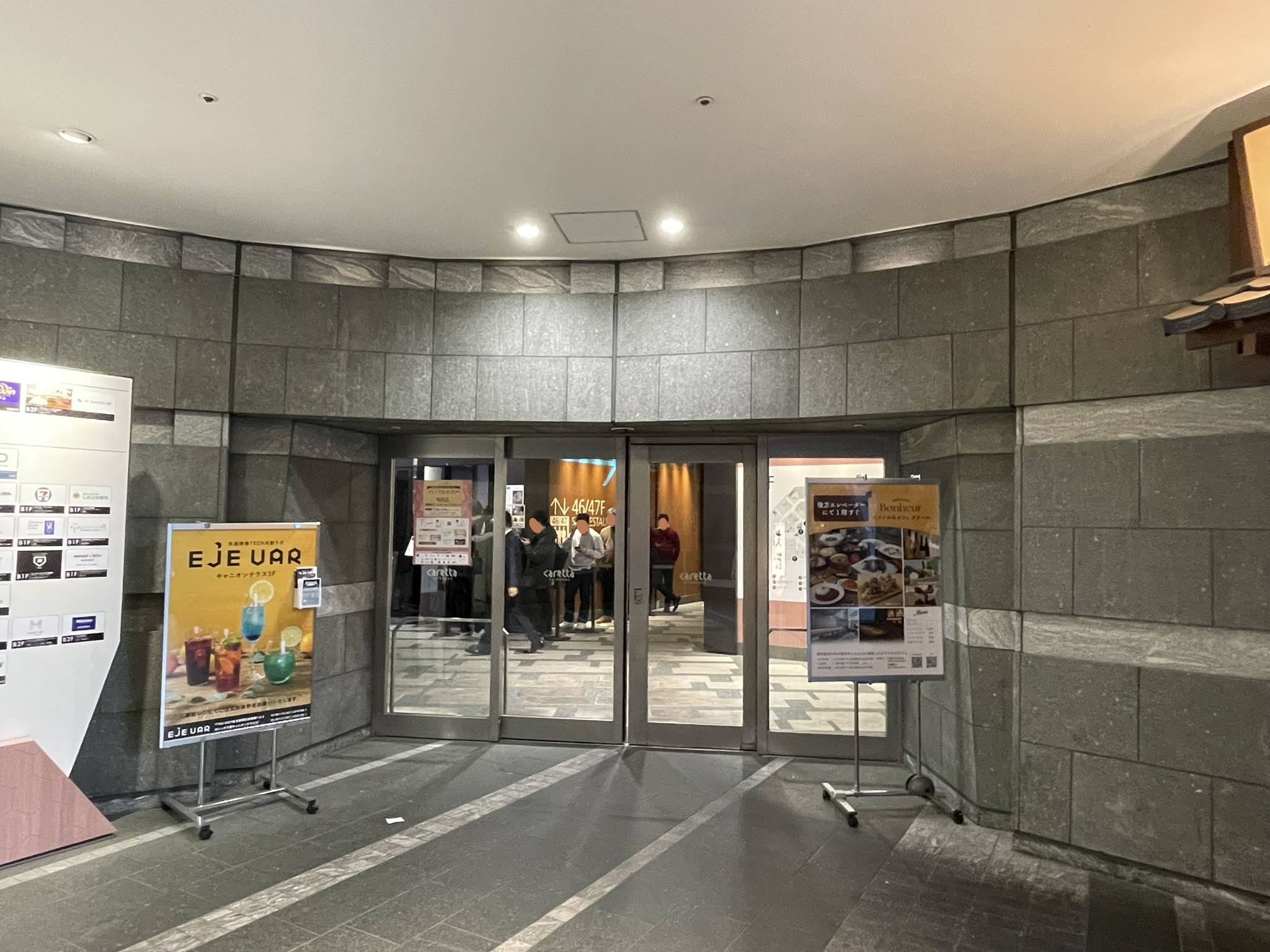 ガラス自動ドアから「そば さやか」さんの入店待ちする人々の姿が見える。