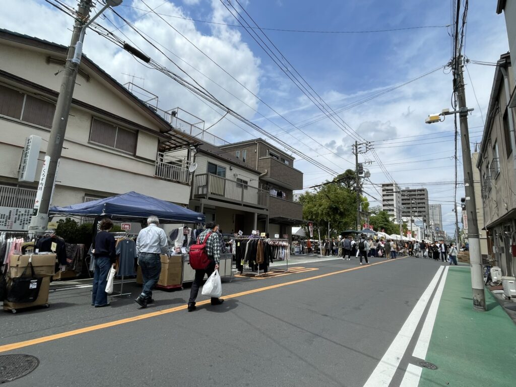 青空のもと、道路に沿って連なるテントと人の列。衣料品やバッグの出店が続き、30社以上が軒を連ねる「こんこん靴市」の規模の大きさが伝わってくる。