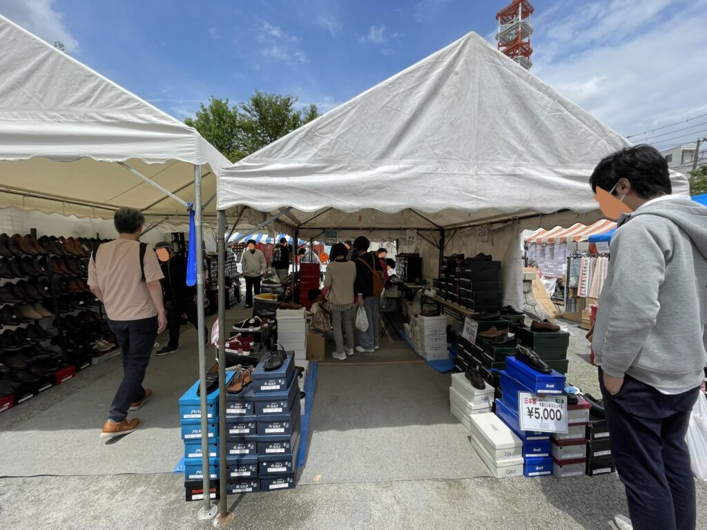 境内に設けられたテント内の靴販売ブース。「日本製ビジネスシューズ ¥5,000」の札が目を引く。30社以上が軒を連ねる境内は、まさに靴の一大市場の様相を呈していた。