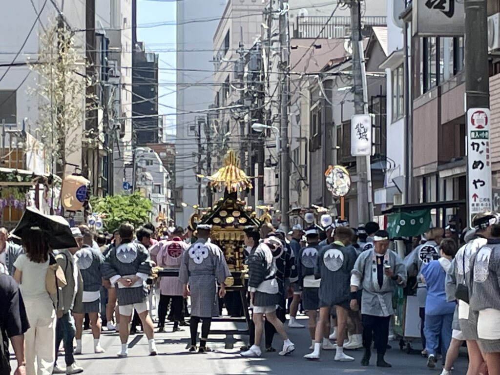 町内神輿を沿道から多くの人が見守っています。