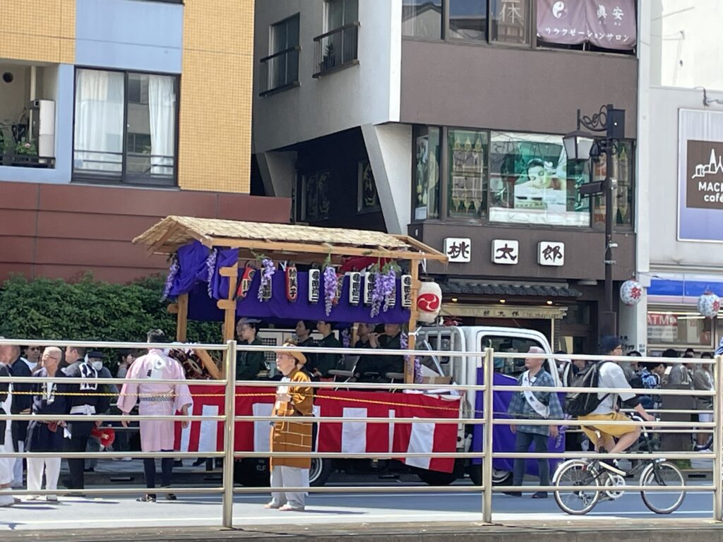 国際通り過ぎる町内神輿。お祭りの賑やかな雰囲気が伝わります。