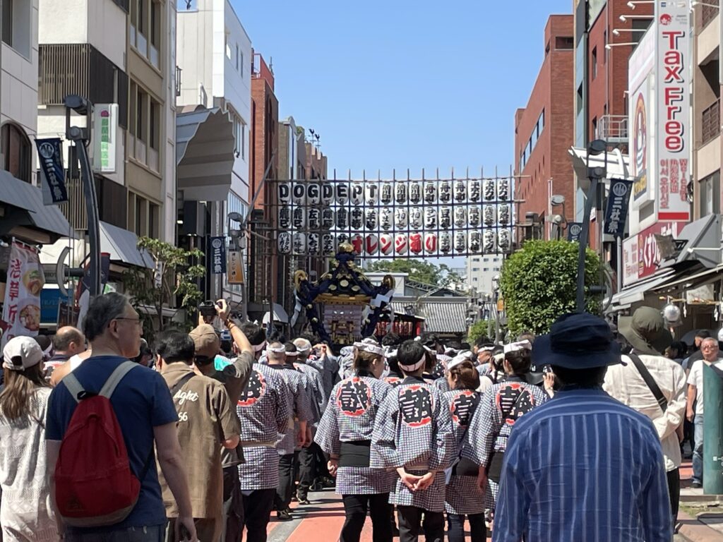 オレンジ通りを進む町内神輿。商店街の賑わいの中を颯爽と練り歩きます。