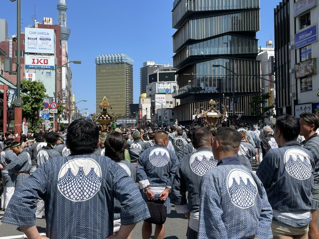 法被姿の担ぎ手たちの背中。揃いの文字が、それぞれの町内の誇りを表しています。