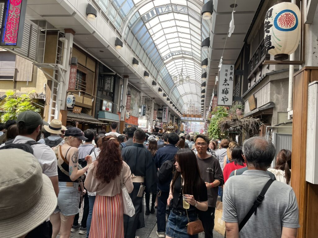 観音通りのアーケードを埋め尽くす人の波。お祭りと買い物客が混ざり合う浅草らしい光景です。