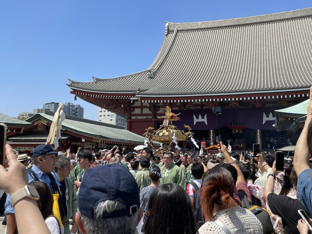 境内を埋め尽くす観衆の中を進む町内神輿。
