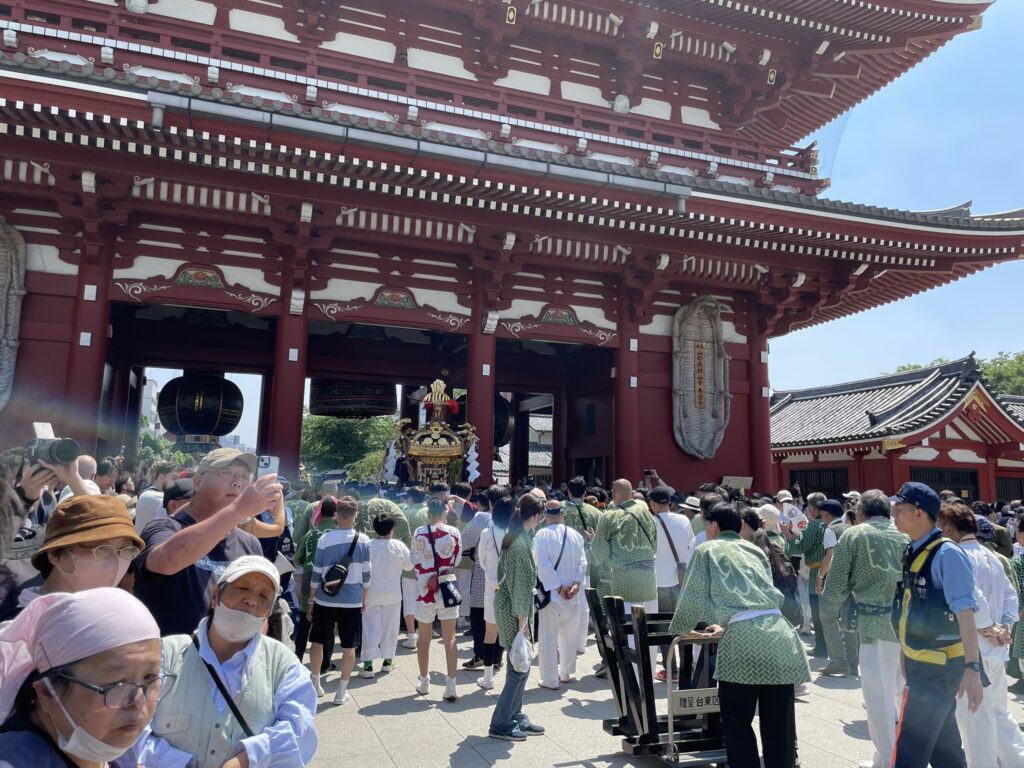 警察官が安全を見守る中、境内を進む町内神輿。
