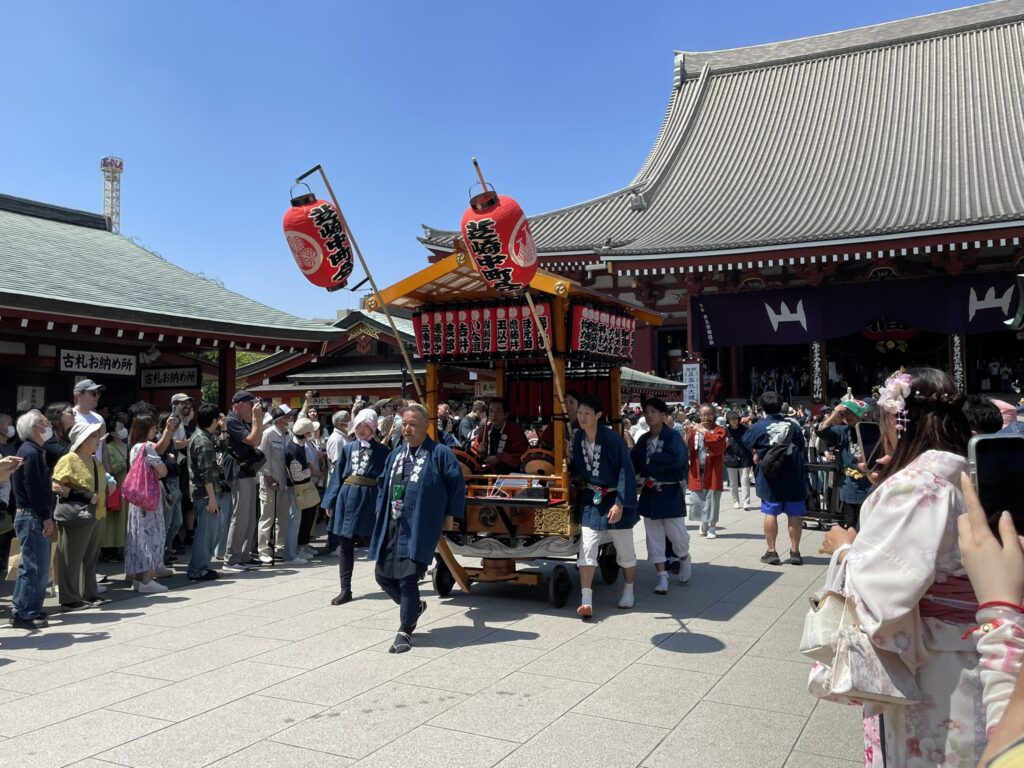 境内から仲見世方向へ向かうお神輿の行列。