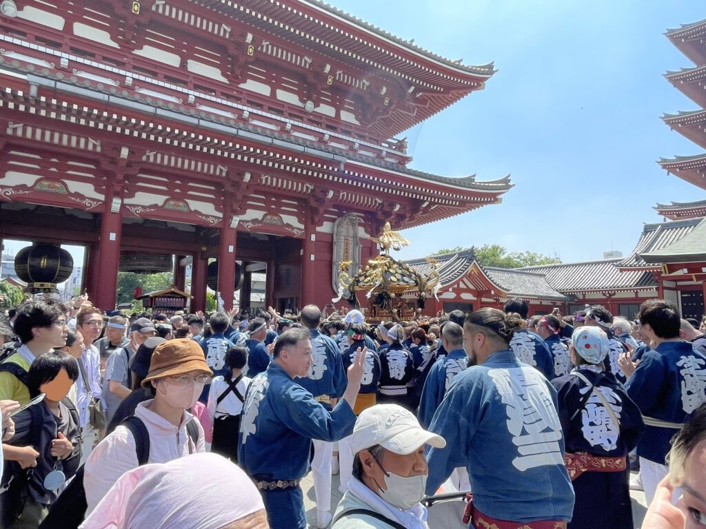 宝蔵門をバックに進む大神輿。法被姿の担ぎ手たちの掛け声が響く。